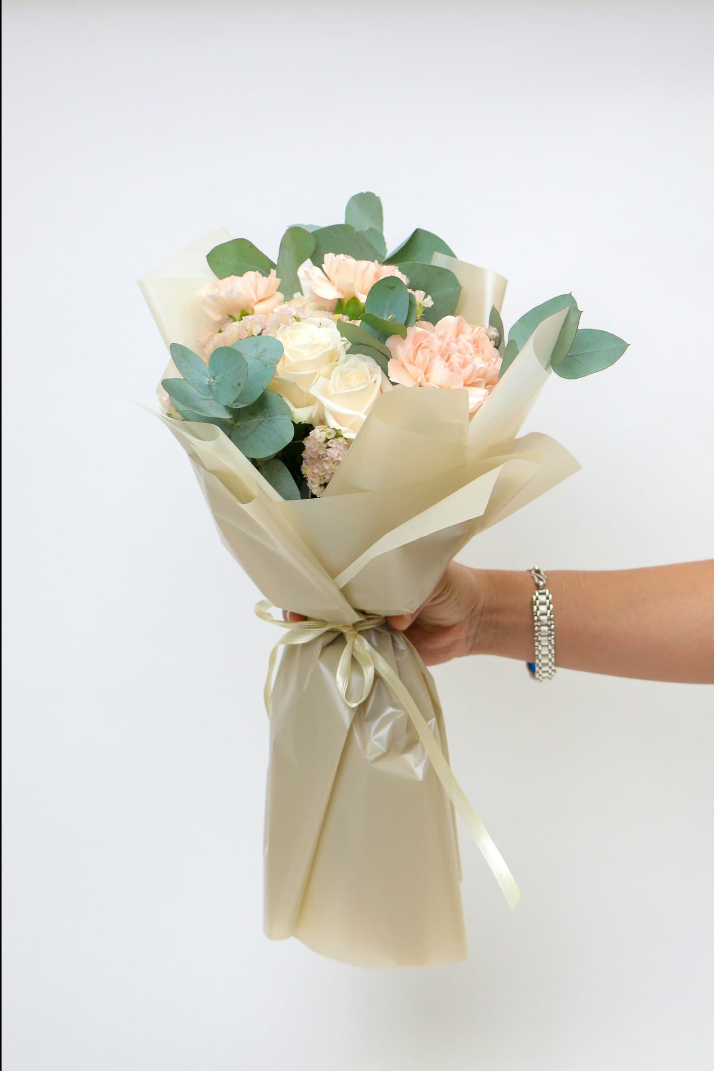 Bouquet de roses pastel dans un papier kraft clair